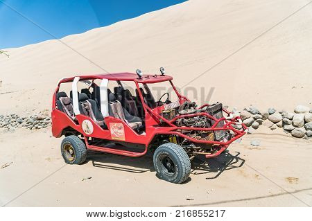 Huacachina Peru - August 2017: Dune buggy at the foot of a large sand dune in Huacachina Peru