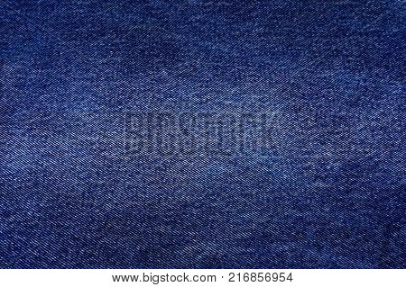 Background. Texture of jeans fabric. Color blue with elements of scuffs. Classical fabric texture. Bright colors. Always in fashion.