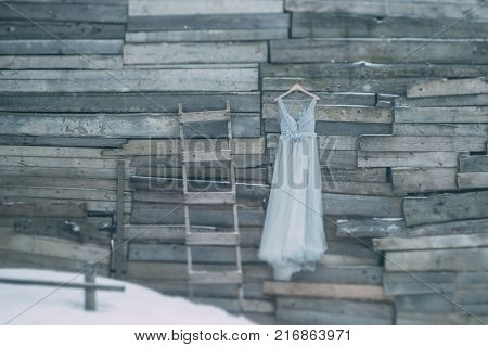 A Beautiful Dress Of Gray Hanging On A Hanger On A Wooden Background