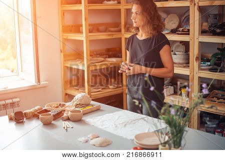 potter, tools, ceramics art concept - handsome young brunette female smiling.