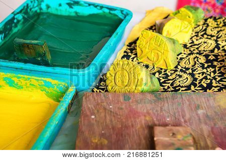 Close up stamps and bright yellow and green dye for cloth