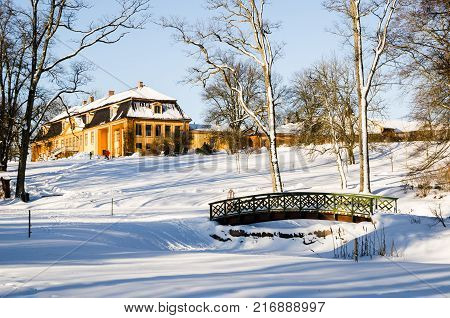 Wooden arch footbridge on a snow covered landscape. Bogstadvannet area in Oslo Norway. Winterscape