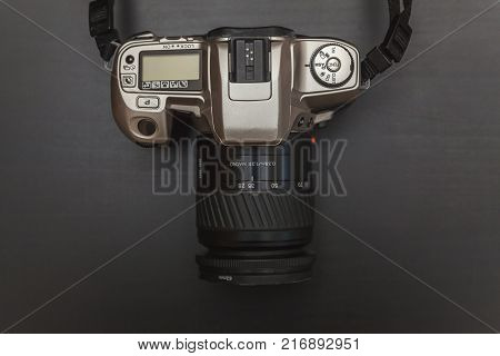 Professional digital camera On Black Wooden Background Technology Development Photographer Concept with copy space. Top View