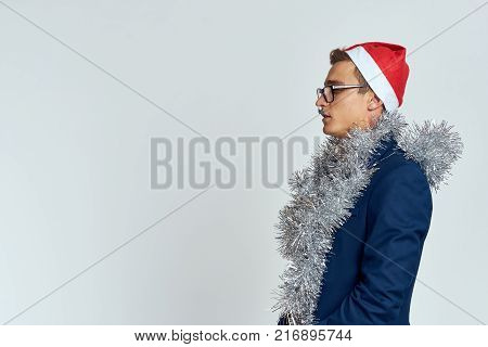 man in suit looks at free space for copy, light background, tinsel, new year, holiday.