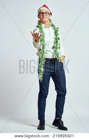 a man in a white shirt in full growth, stretches his arm forward, tinsel, bright background, new year, corporate.