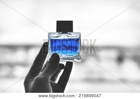 perfume bottle in your hand blue color background