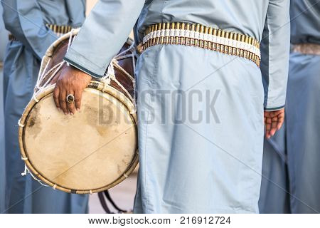 hand of an omani man in traditional outfit with his drum