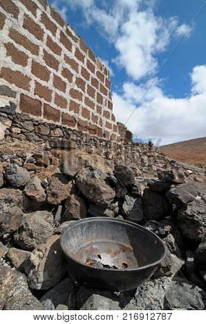 rusty aged metal near a wall on a loudy sky