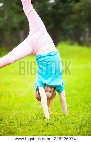 Active Little School Girl Somersault Outdoors.