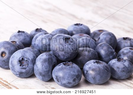 Fruits of northern highbush blueberry (Vaccinium corymbosum) on a wooden board close up