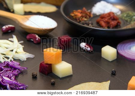 Fresh vegetables for cooking traditional Ukrainian soup borsch. Wooden spoon with salt and spices