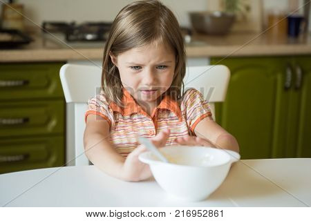 Cute little girl refuses to eat, pushes the plate
