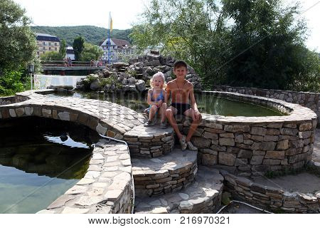 Brother and sister sunbathing in an artificial pond