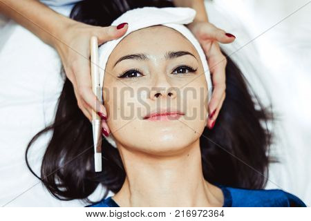 Face massage. Spa skin and body care. Close-up of young woman getting spa massage treatment at beauty spa salon. Facial beauty treatment.