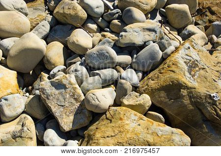boulders and colorful pebbles on the beach on a warm summer day