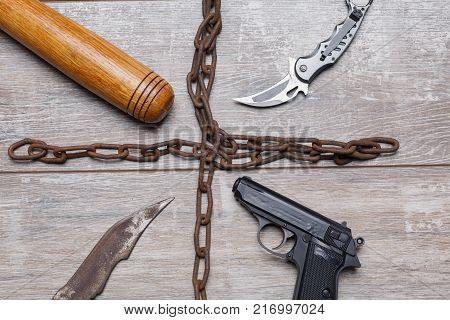 The chain shares items of bandits with bits, a pistol, a knife and a folding knife on the wooden floor