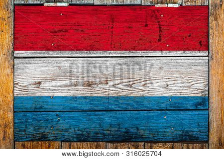 National Flag Of Luxembourg  On A Wooden Wall Background.the Concept Of National Pride And Symbol Of