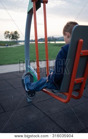 Street Workout Equipment Outdoor Sport Fitness And Bodybuilding. Boy In A Sport Playground Doing Wor