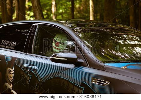 Moscow, Russia - July 13, 2019: Crazy Clown Inside A Tuned Car In The Forest.