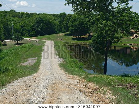 Rugged Road With A Pool Of Water By The Roadside At Chickasaw National Recreation Area In Davis, Okl