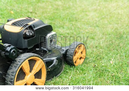 Lawn Mower On Green Grass With Copy Space For Text. Garden Work Concept Background Banner