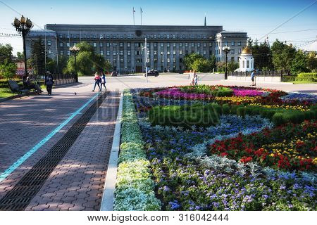 Russia, Irkutsk - July 7, 2019: House Of Soviets, Government Of The Irkutsk Region, Flower Bed And C
