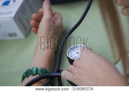 Hands Measure Blood Pressure With A Device