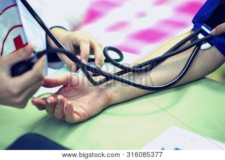 The Doctor Measures The Pressure Of The Patient