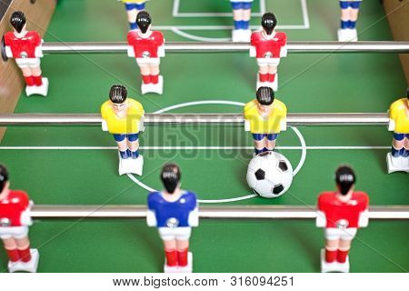 Table Football Game With Yellow, Red And Blue Plastic Players.