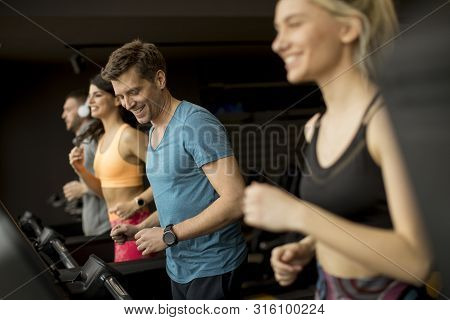 Young People Using Threadmill In Modern Gym