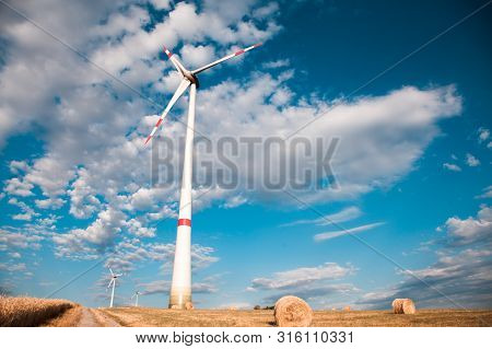 Windmills For Electric Power Production On The Field Of Cereal.