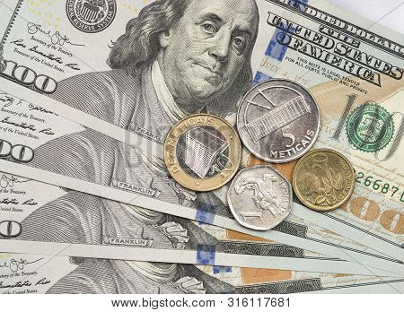 Mozambique Metical Coin On Top Of Dollar Bills For Financial And Investment Concepts