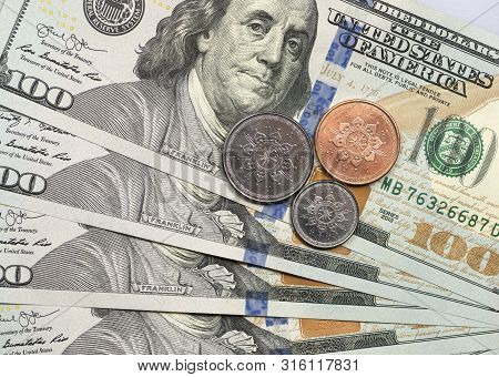 Rial Omani Coin On Top Of Dollar Bills For Financial And Investment Concepts