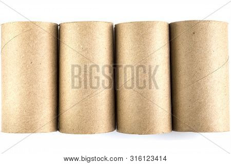 Top View Of Four Cardboard Paper Tubes In The Row On White Background. Close-up Of Empty Toilet Roll