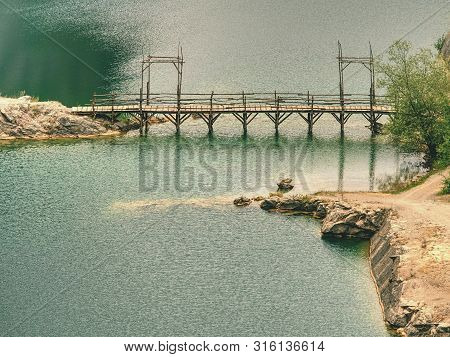 Green Blue Lake With Wooden Tourist Path Bridge Above Cold Water. Hiking In The National Park