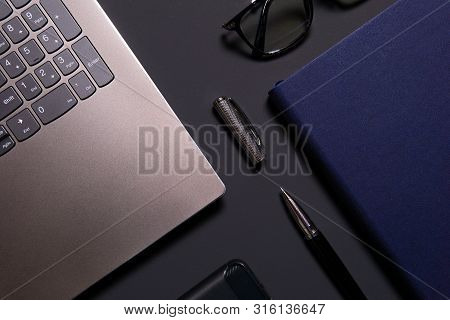 Notebook, Laptop, Glasses And Pen On The Table.