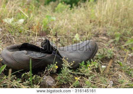 Old Abandoned Leather Boot Lying In The Grass