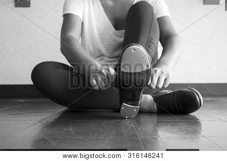 Black And White Version Of Tap Dancer Sliding On Her Tap Shoes In The Dance Studio During Dance Clas