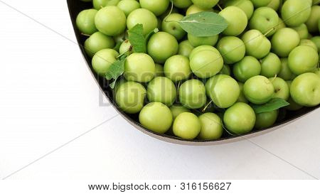 Green Plums On White Ground, Fresh Plums, Sour Plums In A Container, Green And Sour Plums,