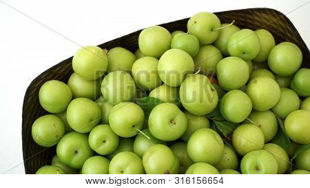 Green Plums On White Ground, Fresh Plums, Sour Plums In A Container, Green And Sour Plums,