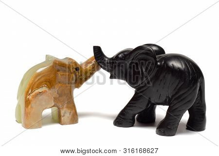 Figurines Of Elephants Play On A White Background
