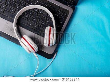 White Red Music Headphones On Technology Background Notbook Computer On A Blue Background. Happy Hol