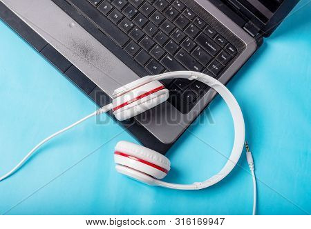 White Red Music Headphones On Technology Background Notbook Computer On A Blue Background. Happy Hol