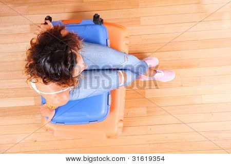 Ragazza seduta su valigie
