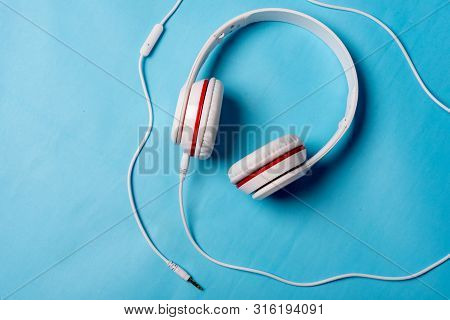 White Red Music Headphones On Technology Background Notbook Computer On A Blue Background. Happy Hol
