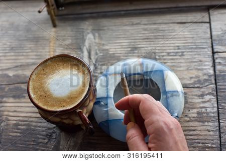 Coffee Cigarette On The Table. Cigarette In A Womans Hand With A Beautiful Manicure. Blue Ashtray. T