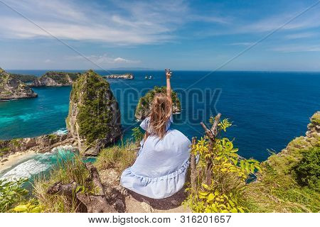 Young Woman Raised Her Hand Up In Thousand Island. Aerial View Of Nusa Batumategan And Nusa Batupada