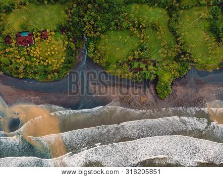 Aerial View Of Black Sand Beach With Ocean And Waves In Balian, Bali