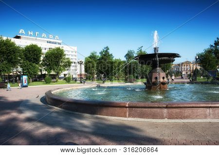 Russia, Irkutsk - July 7, 2019: Fountain And Hotel Angara In Tikhvinsky Or Kirov Square In Sunny Sum