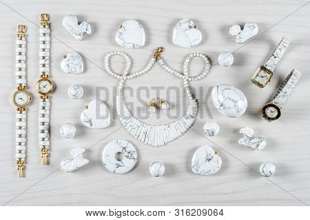 Flat Lay White Howlite Items On White Wooden Background. Top View Semi Precious Jewelry Concept.